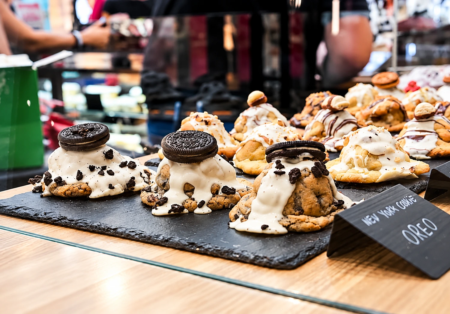 Cookies artesanales con crema blanca y Oreo sobre pizarra